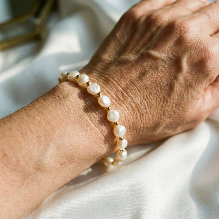 Pulsera retro blanca con perlas y detalles dorados